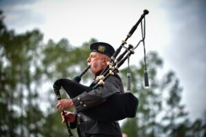 pexels-photo-10706365-10706365 Man playing bagpipes outdoors, showcasing traditional Scottish music, in Spring Lake, NC.