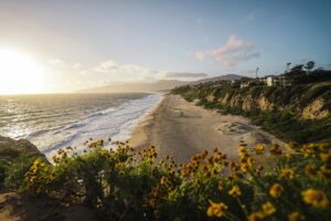 pexels-photo-18303333-18303333 Captivating view of Malibu beach at sunset with waves and cliffs in California, USA.