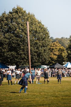 pexels-photo-31467521-31467521 Participants compete in the traditional caber toss at the Scottish Highland Games in a lush outdoor setting.